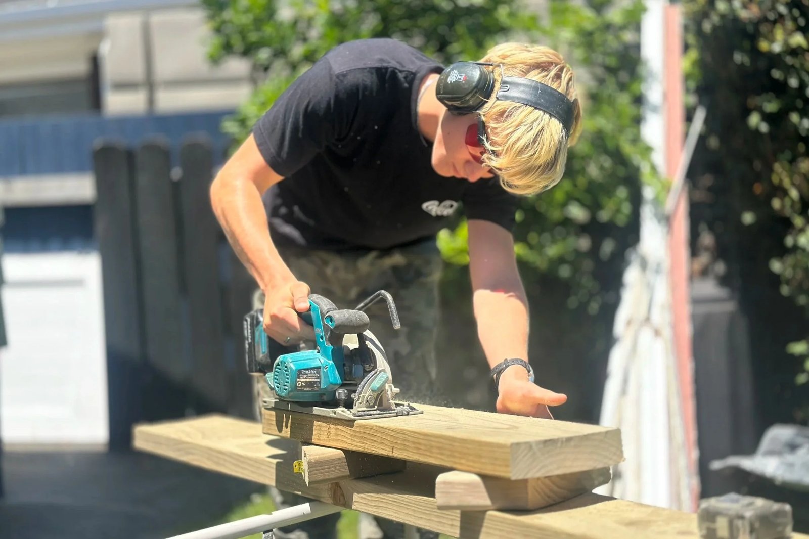 Cutting a garden gate board on site in Shelly Park, East Auckland